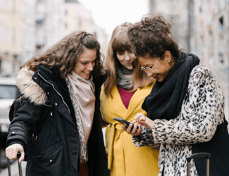 group of women travelers looking at a smart phone