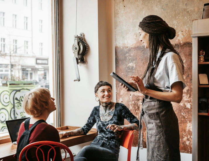 server taking an order from female patrons