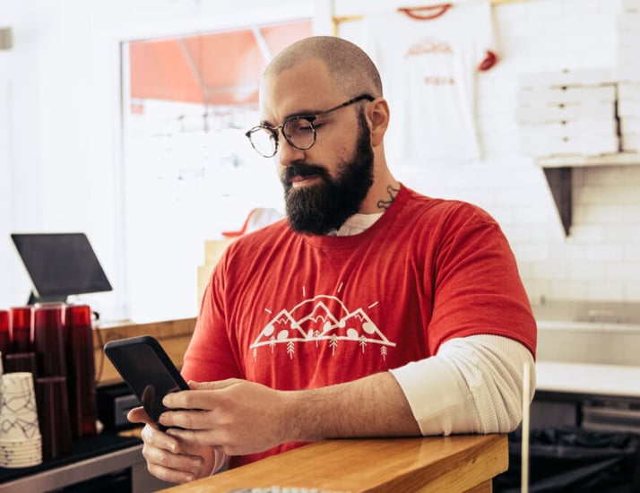 man in restaurant on smart phone