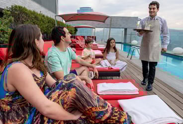 server bringing drinks to couple on vacation