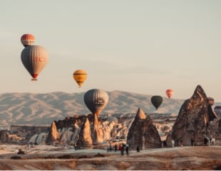 Hot air balloons over a landscape.